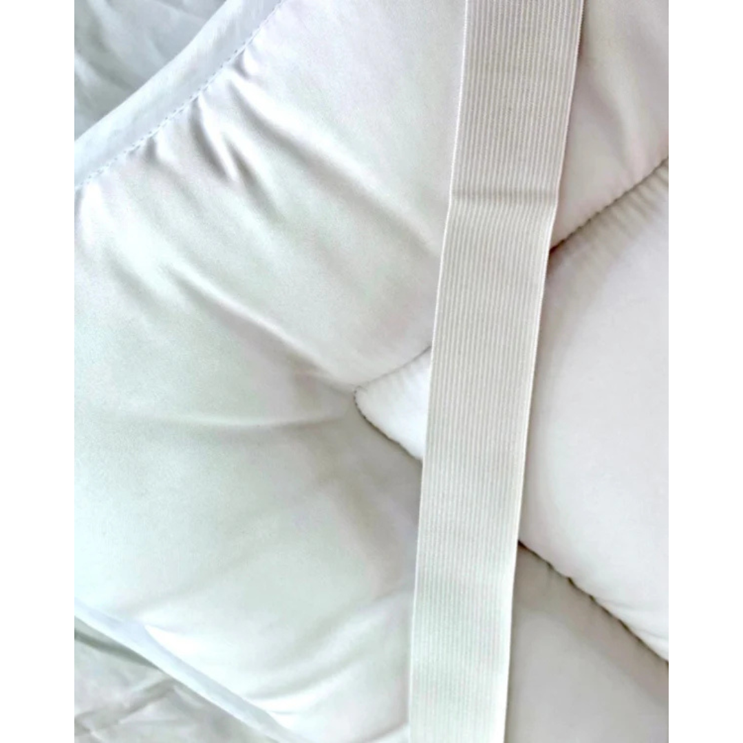 Close-up of the 2" CoolCloud™ Down Alternative Topper for Elevra beds, showing its white quilted surface and textured elastic strap for secure fit. This topper offers cool, hypoallergenic comfort and protection.