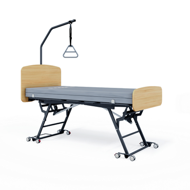 The Accora Contesa® FloorBed® Hi/Low Full Electric Bed features a light wood headboard and footboard, gray mattress, black wheeled metal frame, and overhead trapeze bar—an ideal fall-prevention solution for patient mobility and safety.