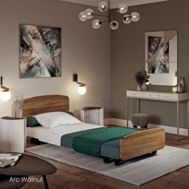 A modern bedroom with a single Accora Contesa® FloorBed® Hi/Low Full Electric Bed featuring walnut accents and a green blanket, abstract wall art, stylish lighting, a white console table, and plants on a light rug and wooden floor.