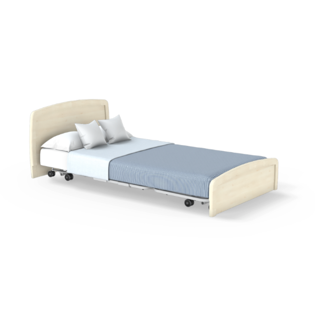 The Accora Empresa® Full Electric Bariatric FloorBed® features a light wood headboard and footboard, two white pillows, a crisp white bedsheet, and blue blanket. Shown on wheels for mobility and isolated on a white background.