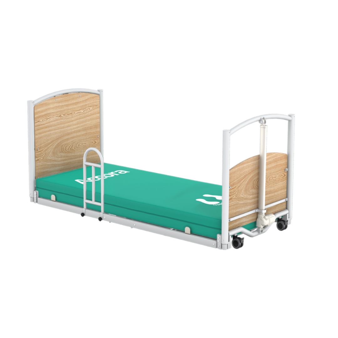 The Short Stand-Assist Bar for Accora FloorBed is shown attached to a hospital bed with a green mattress, light wood headboard and footboard, white metal frame, side rails, and wheels against a plain white background.