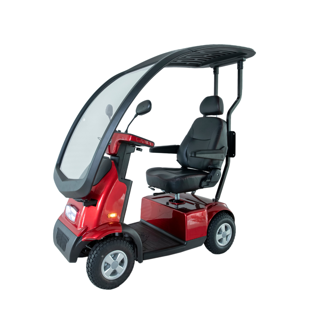 The Afikim Afiscooter C4 HD is a red electric 4-wheel mobility scooter with a canopy, orthopedic cushioned seat, armrests, and steering panel. Designed for comfort, it includes a transparent front shield for protection.