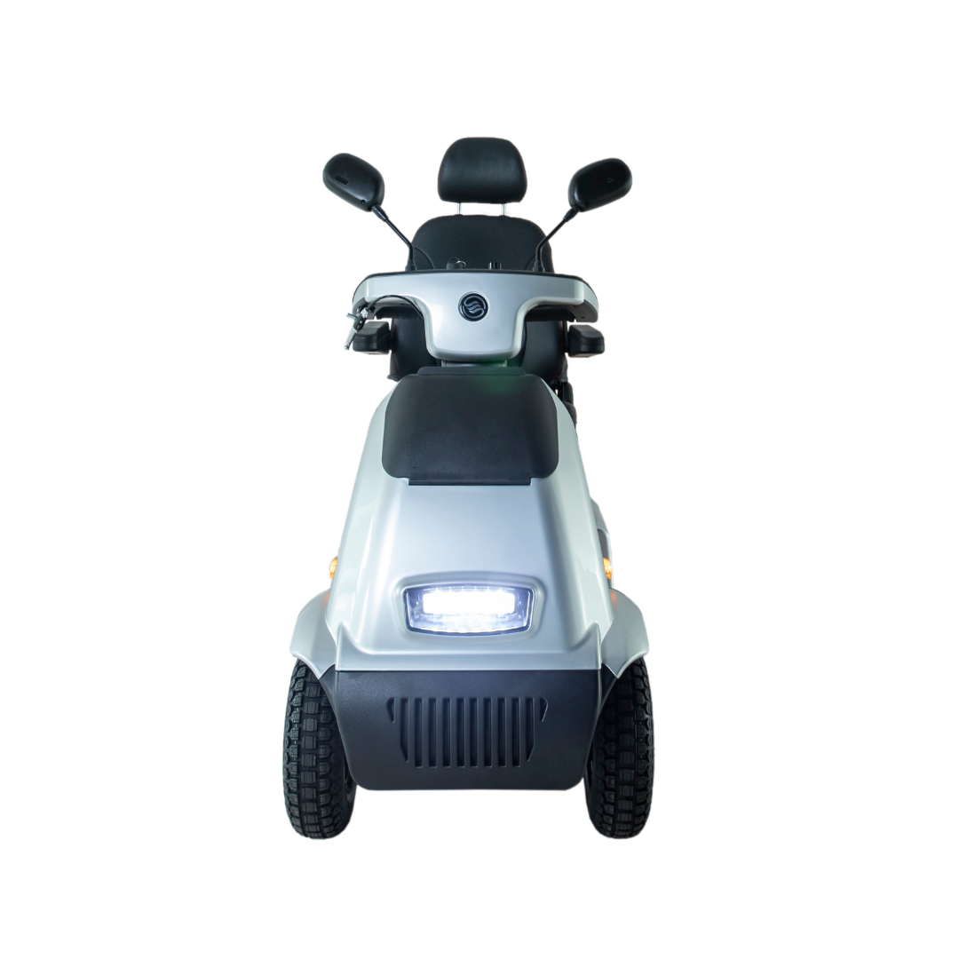 Front view of the Afikim Afiscooter C4 HD, a sleek, compact 4-wheel mobility scooter in silver with two rearview mirrors, an orthopedic seat, large treaded wheels, and an illuminated headlight.