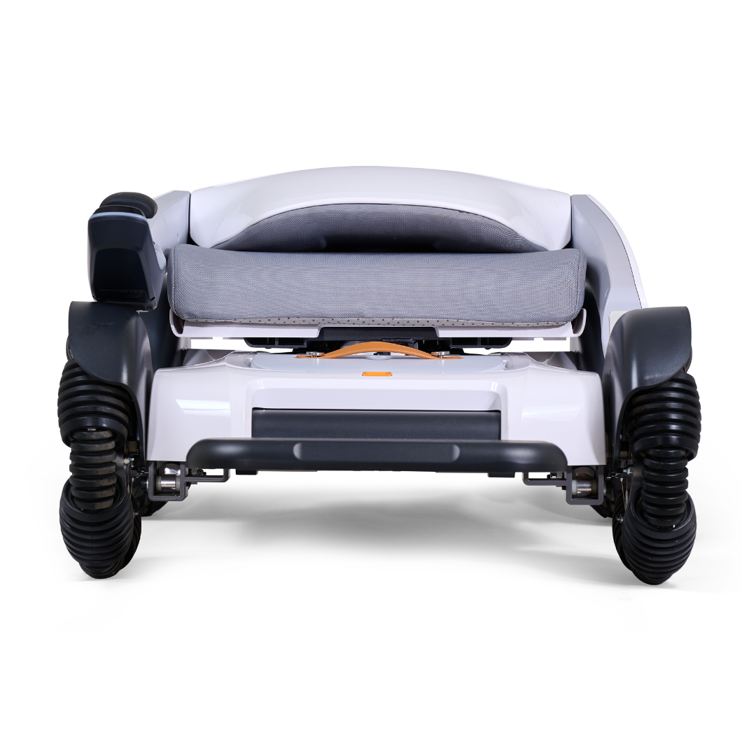 The Golden Tech Ally Sport Smart Powerchair, shown from the front, features a white and gray design, omni-directional wheels, app control, and a compact frame with a folded-down cushioned seat.