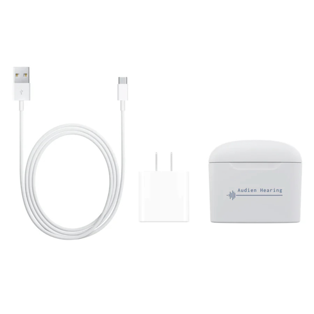 The Audien Hearing Atom Pro Charger + Case, featuring a white hearing aid charging case, USB-A to USB-C cable, and wall adapter, is displayed on a plain white background.