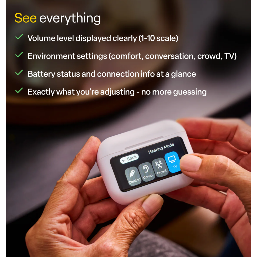 Close-up of hands holding Audien Hearing Atom X Hearing Aids with Digital Case Control, featuring an intuitive touchscreen that displays hearing modes like Comfort, Conversation, Crowd, and TV, along with volume level and battery status.