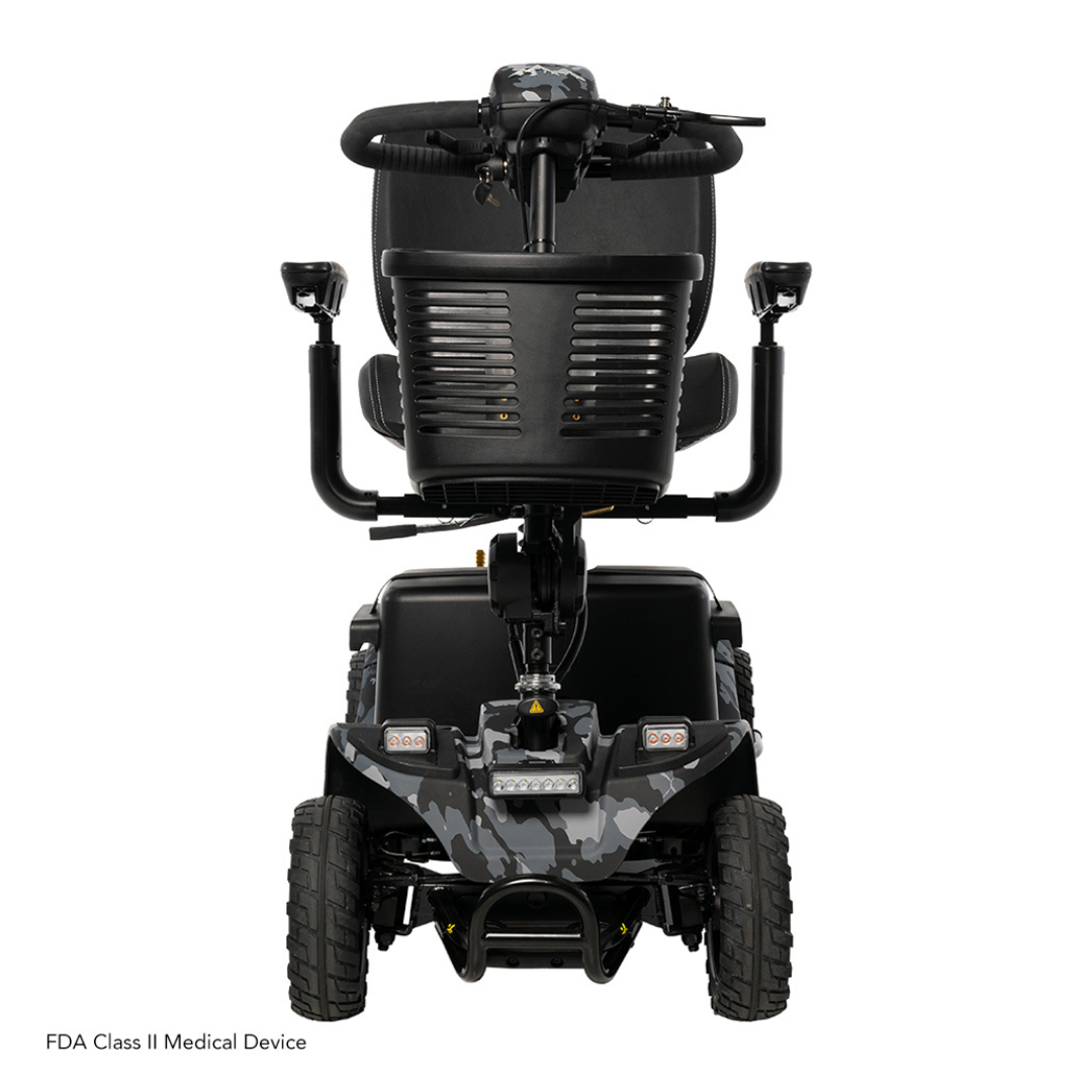 The rear view of the Pride Baja® Bandit 4 Wheel Scooter showcases a black mobility scooter with rugged tires and camo accents, ideal for off-road trips. It has armrests, a cushioned seat, handles for control, and a rear basket labeled FDA Class II Medical Device.