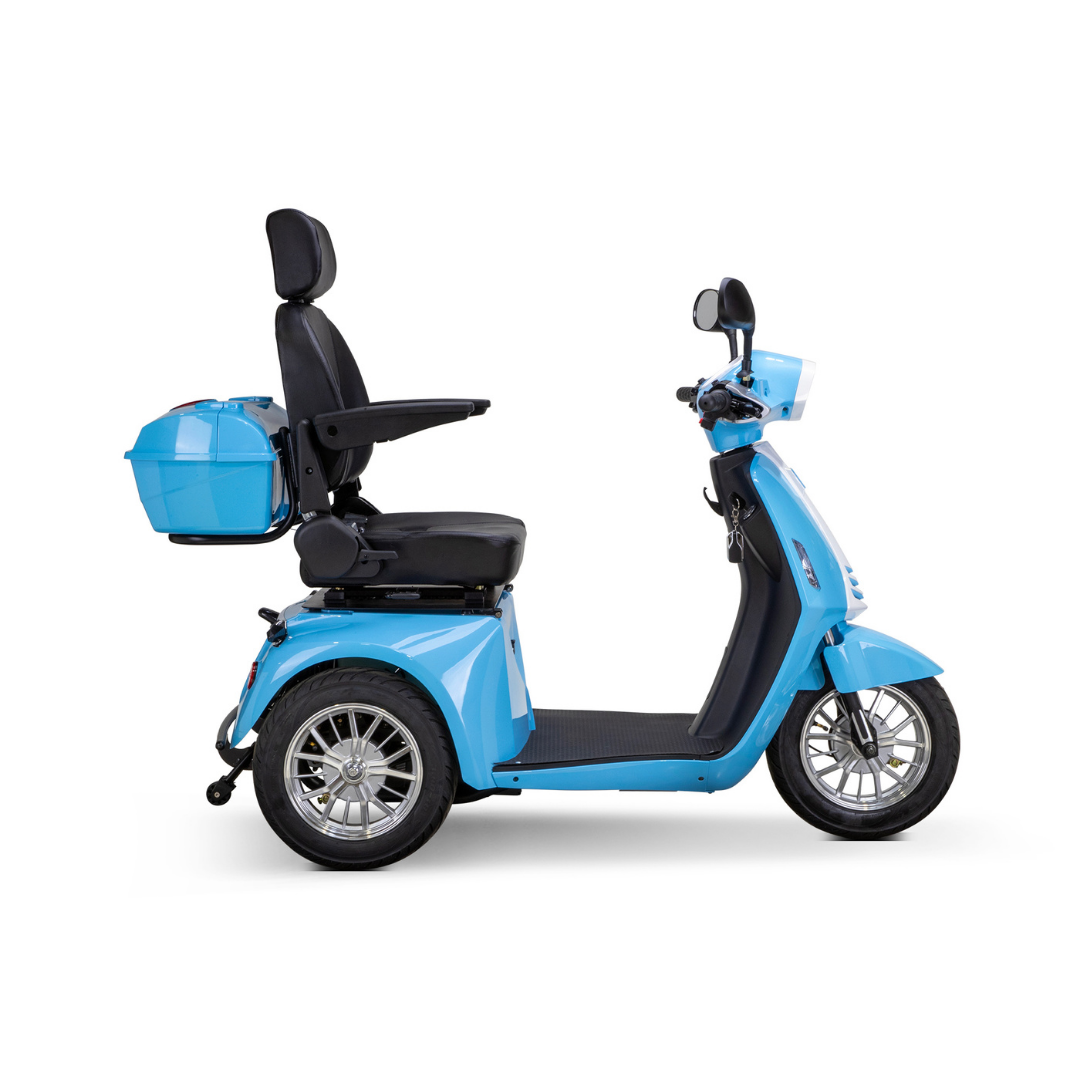 The Bespoke Elite Recreational 3-Wheel Scooter with Electric Brake Assist in light blue features a 600-watt motor, black cushioned seat with high backrest and armrests, plus a rear storage box, shown from the side against a white background.