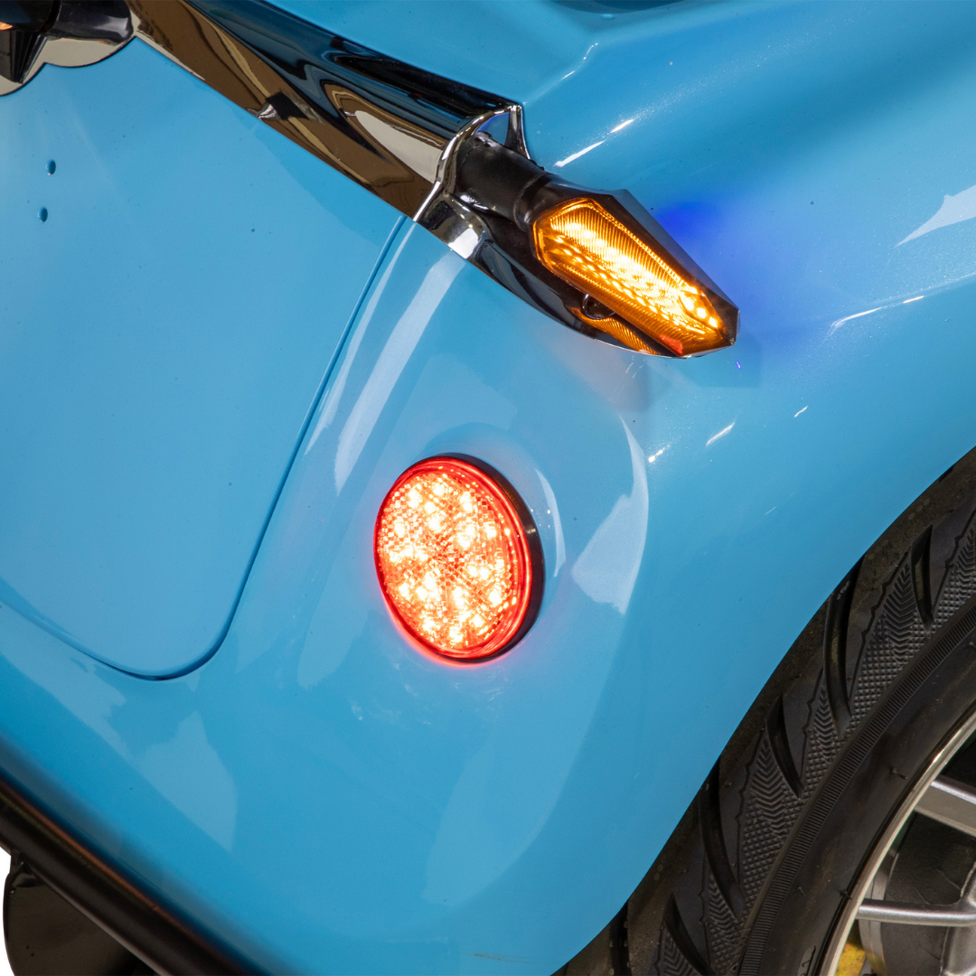 Close-up of the Bespoke Elite Recreational 3-Wheel Scooter’s rear, featuring a lit red brake light, amber turn signal, black tire with visible tread pattern, and digital speedometer display.