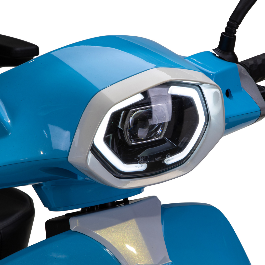 Close-up of the Bespoke Elite Recreational 3-Wheel Scooter’s blue front panel with an angular LED headlight, white border, reflective surface, black grip handlebars, and a digital speedometer for taller riders. Features electric brake assist.