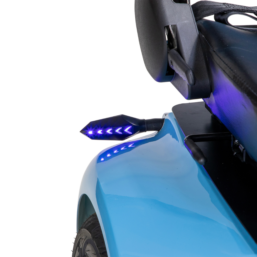 Close-up of the Bespoke Elite Recreational 3-Wheel Scooter with Electric Brake Assist, featuring blue arrow-shaped indicator lights on the rearview mirror, a seat, part of the rear wheel, and a digital speedometer for tall riders.