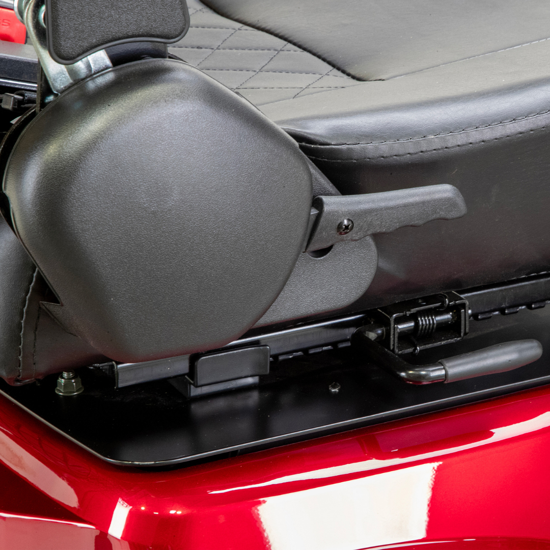 Close-up of a black armrest adjustment lever on the side of a diamond-stitched padded seat, mounted on a shiny red Bespoke Legacy Recreational 3-Wheel Scooter with a powerful 600-watt motor.