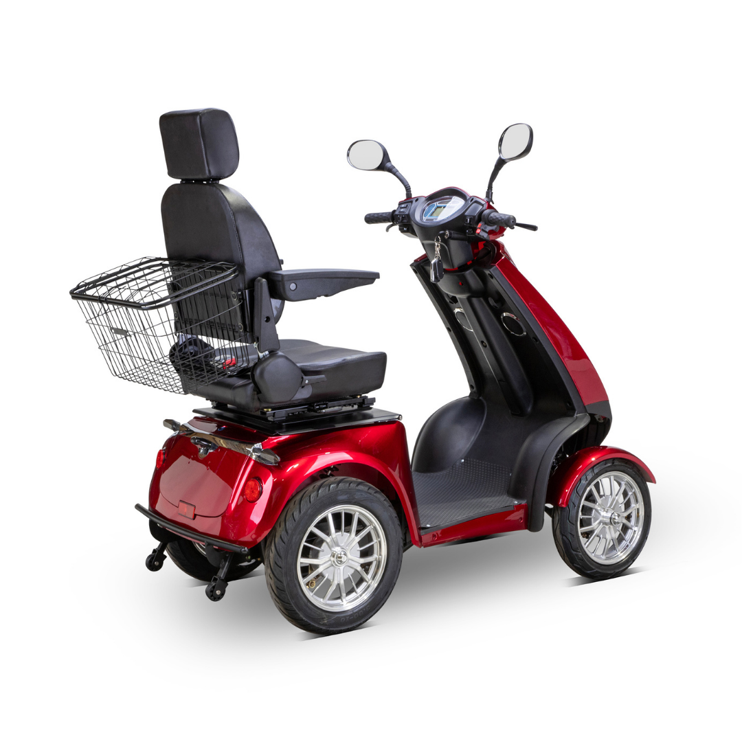The Bespoke Platinum Recreational 4-Wheel Scooter with Electric Brake Assist is shown in red, featuring a black cushioned seat with headrest, rearview mirrors, and rear metal basket, viewed from a rear side angle on a white background.