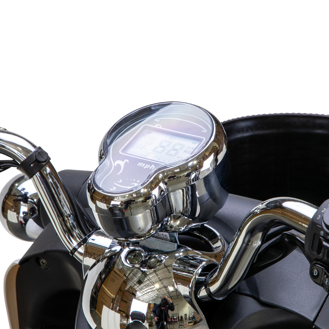 Close-up of the Bespoke Supreme Euro-Style Recreational 3-Wheel Scooters chrome-trimmed digital speedometer on the handlebars, showing speed in mph and highlighting the advanced dashboard technology and reflective details.