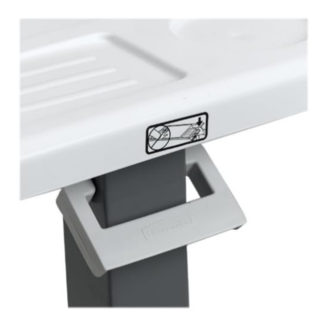 Close-up of a Carex Height Adjustable Rolling Overbed Table with XL Surface, showing its white plastic corner, gray rectangular support leg, and warning label with an image advising not to place fingers near the edge.
