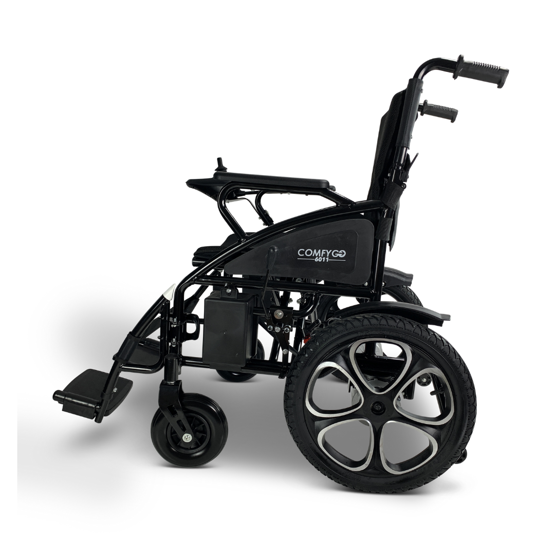 Side view of the lightweight black ComfyGO 6011 folding electric wheelchair with large rear and smaller front wheels, raised armrests, and a curved handlebar. Its footrest is lowered.