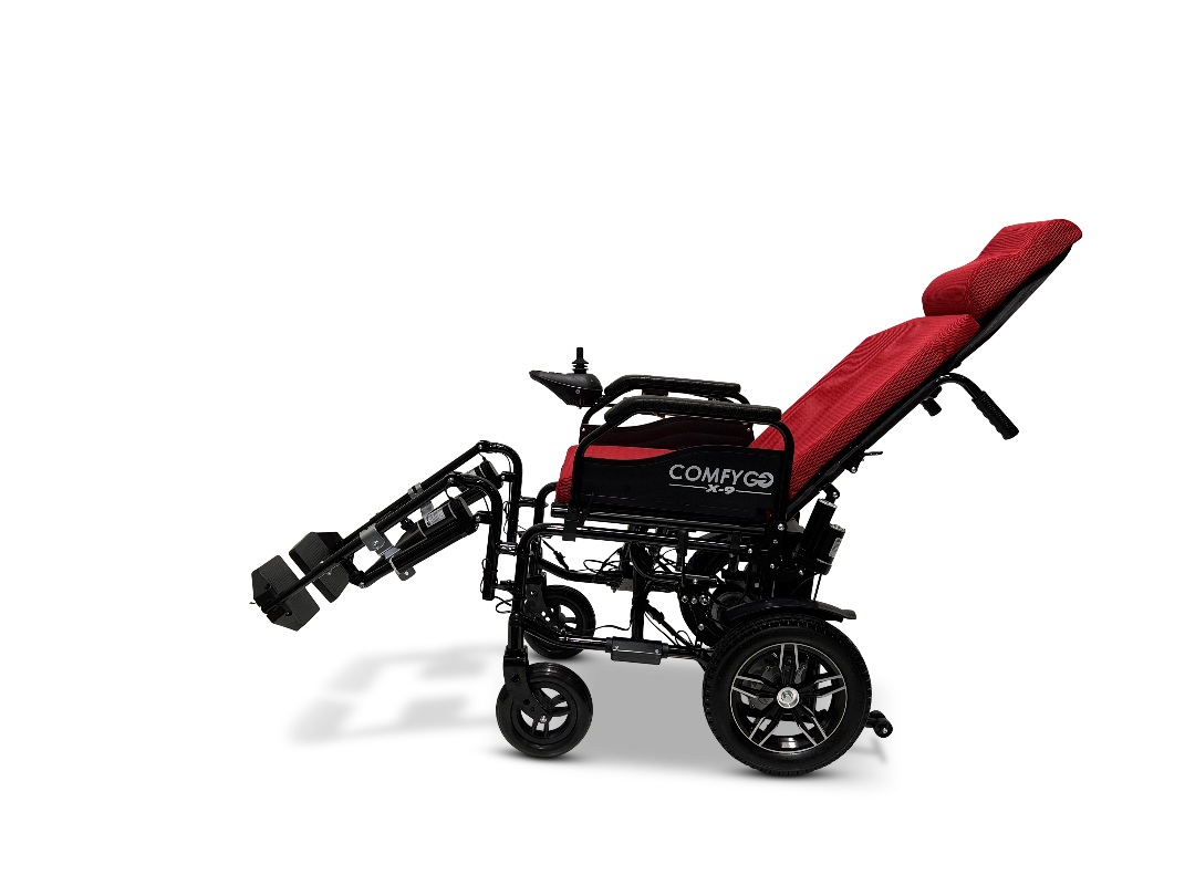 The ComfyGo X-9 Remote Controlled Powerchair, in sleek black and red, features a reclining backrest, adjustable footrests, and cushioned seating. Viewed from the side on a white background, it showcases its cutting-edge mobility solutions.