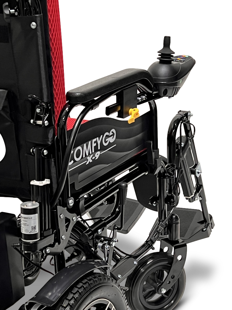 Close-up view of the black and red ComfyGo X-9 Remote Controlled Powerchair, featuring its backrest, armrest, joystick controller, and wheel part. This remote-controlled mobility solution highlights the powerchairs design and features.