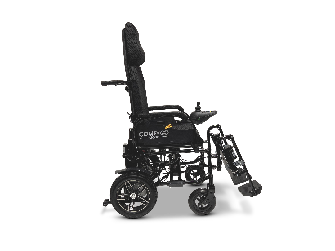The ComfyGo X-9 Remote Controlled Powerchair is shown in profile against a white background. This black mobility solution, featuring large rear wheels, smaller front wheels, a headrest, folded footplate, and branded COMFYGO offers automatic reclining for added comfort.