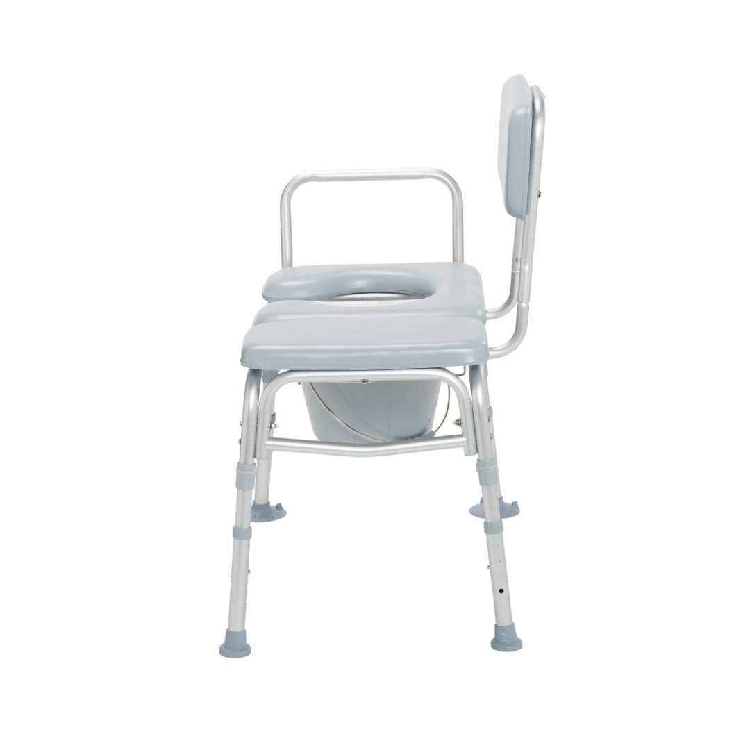 Side view of the Drive Combination Padded Transfer Bench/Commode in light blue and white, featuring armrests, an open-centered padded seat, a removable bucket below, and adjustable rubber-tipped legs for enhanced stability.