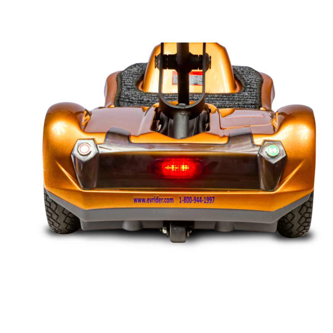 Rear view of the EV Rider TranSport S19AF Automatic Folding Travel Scooter in orange, featuring a textured seat, illuminated red rear light, green and red rear reflectors, plus visible website and phone number on the lower bumper.