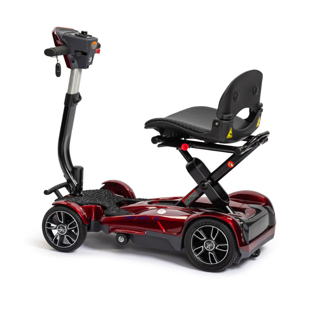 The EV Rider Transport 4M Travel Scooter is a red, four-wheeled electric scooter with a black cushioned seat, armrests, a backrest, and a handlebar control panel—ideal for lightweight travel, shown on a white background.