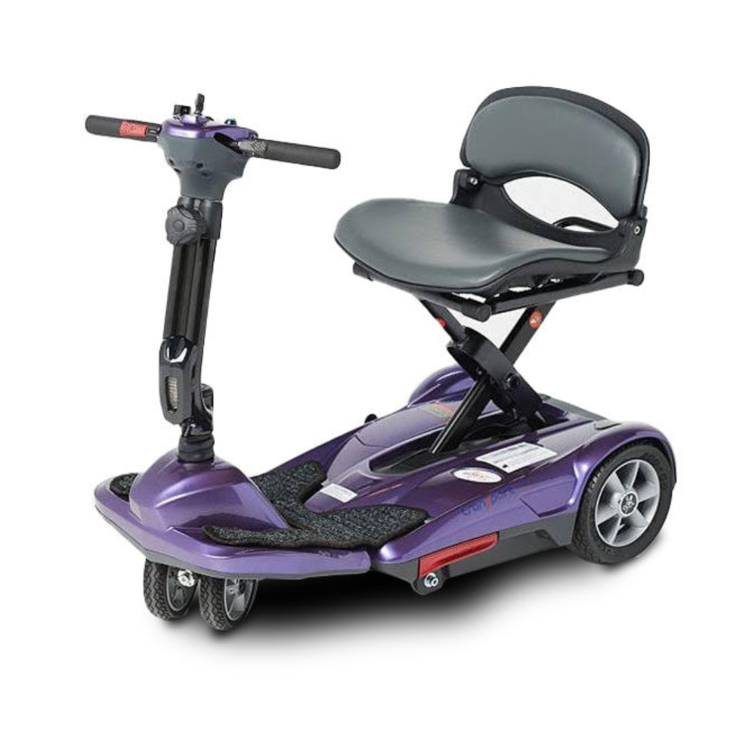 The EV Rider TranSport M Easy Move S19M is a compact, purple folding travel scooter with four wheels, a black cushioned seat, raised armrests, and handlebars, designed for personal mobility. Shown against a white background.