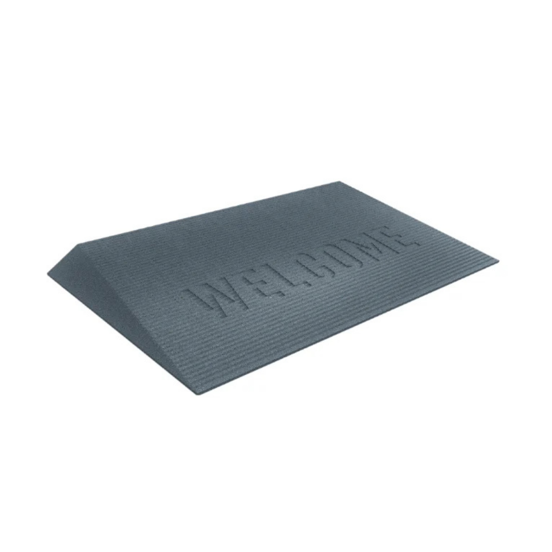 The EZ-Access TRANSITIONS® Angled Entry Welcome Mat is gray with WELCOME embossed on its slip-resistant, recycled rubber surface. It features a simple textured design and slightly elevated edges, shown on a white background.