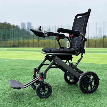 The Easwe™ E10 Portable Lightweight Electric Wheelchair, featuring a black frame and mesh seat, is placed on green artificial turf with trees and tall buildings visible in the background.
