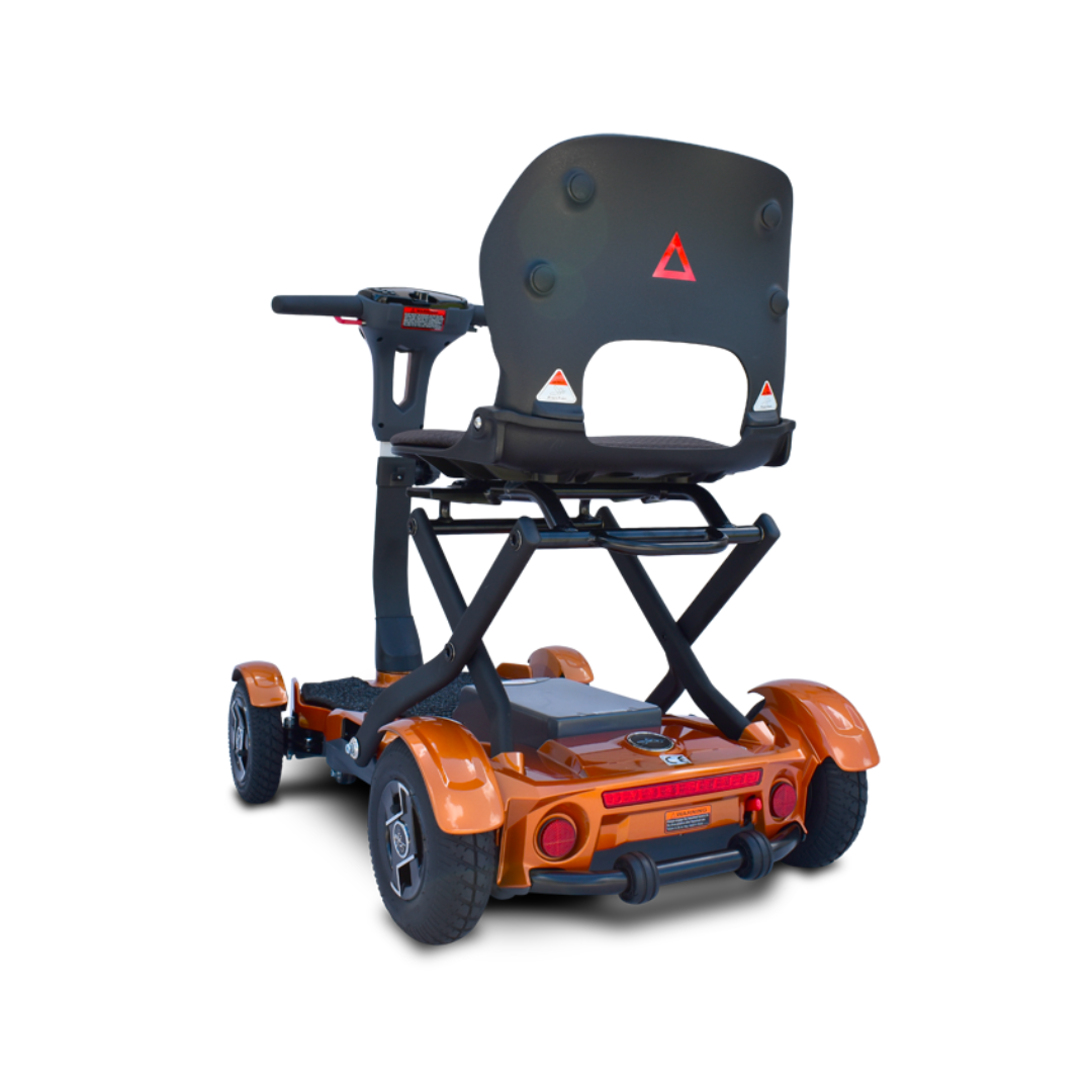 The EV Rider Teqno Automatic Folding Portable Travel Scooter is a four-wheeled orange mobility scooter with a raised seat, black backrest, sturdy frame, and triangular reflector, shown from the rear on a white background.