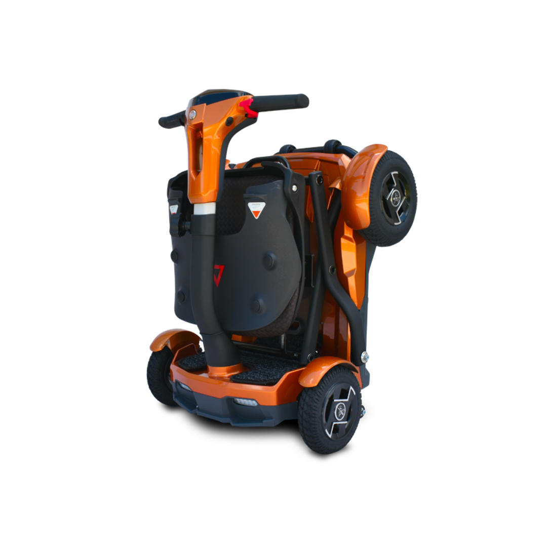 The EV Rider Teqno Automatic Folding Portable Travel Scooter, shown in orange with black accents, is compact and folds upright with wheels on the sides, making it ideal for easy storage or transport.