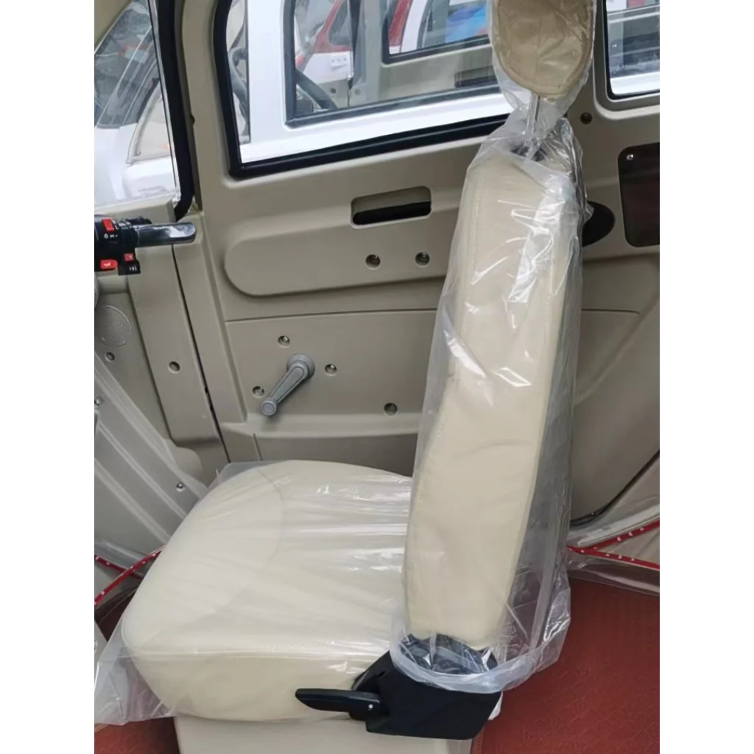 A close-up of a beige car seat covered in protective plastic inside the GIO Golf Fully Enclosed Mobility Scooter with Heater and Cooling Fan. The interior door panel with manual window controls and a red floor mat is visible.