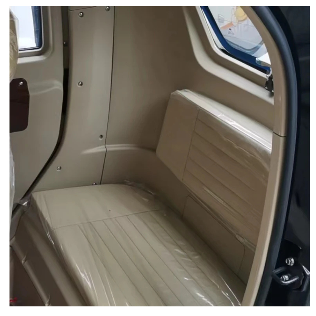 Interior view of a beige GIO Golf Fully Enclosed Mobility Scooter with Heater and Cooling Fan, featuring a plastic-covered bench seat, side panel, and a window on the right side.