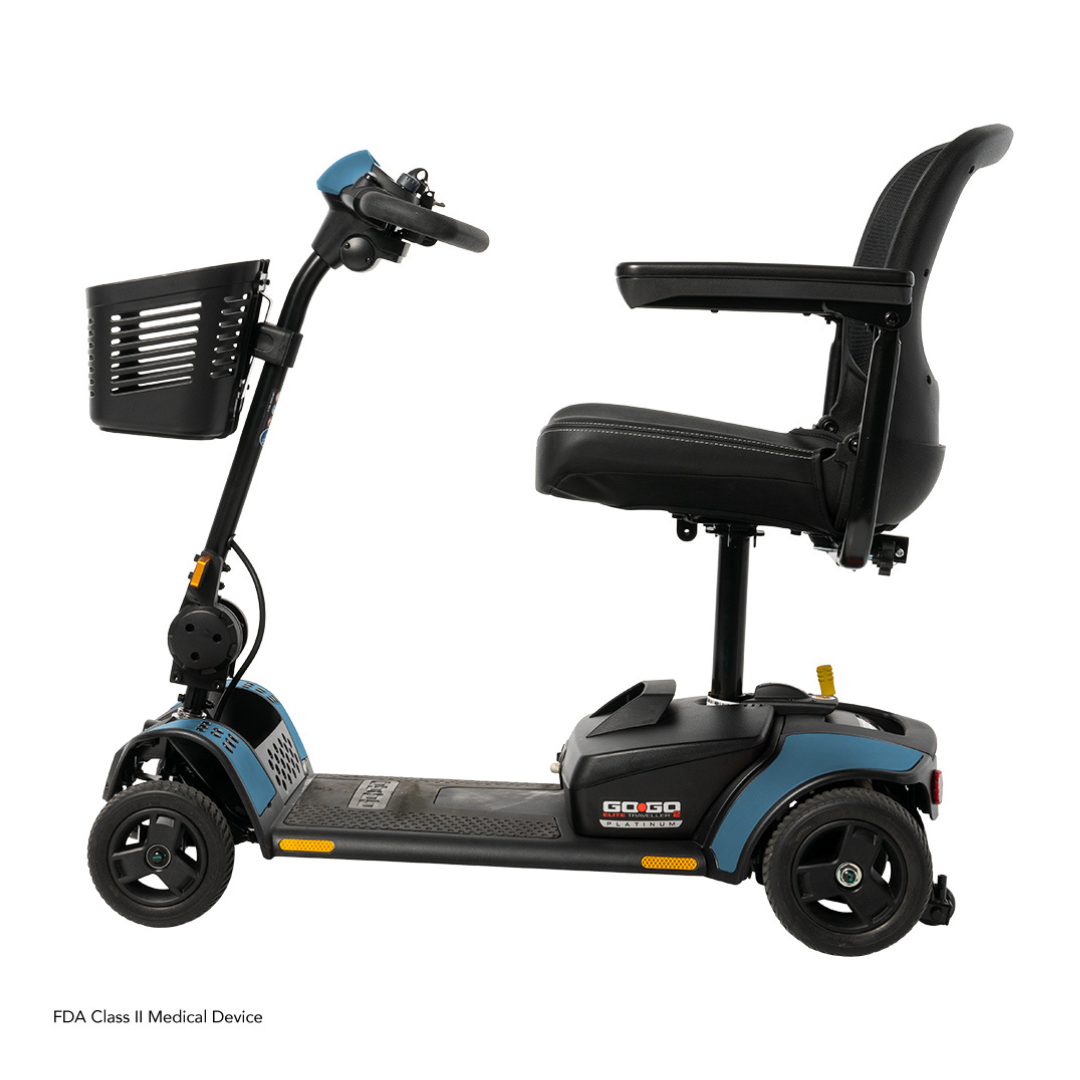 The Pride Mobility Go Go Elite Traveller® 2 Platinum Scooter in blue and black is a three-wheel travel scooter with a front basket, padded seat, armrests, and control handlebar, shown from the side against a white background.