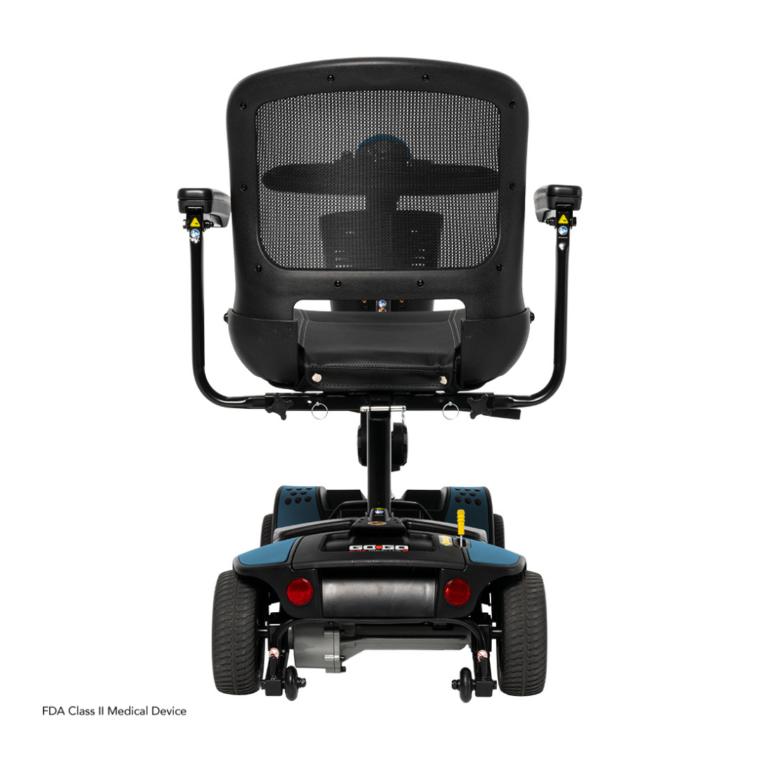Rear view of the Pride Mobility Go Go Elite Traveller® 2 Platinum Scooter with mesh-back seat, armrests, large rear wheels, and an FDA Class II Medical Device label shown on a white background.