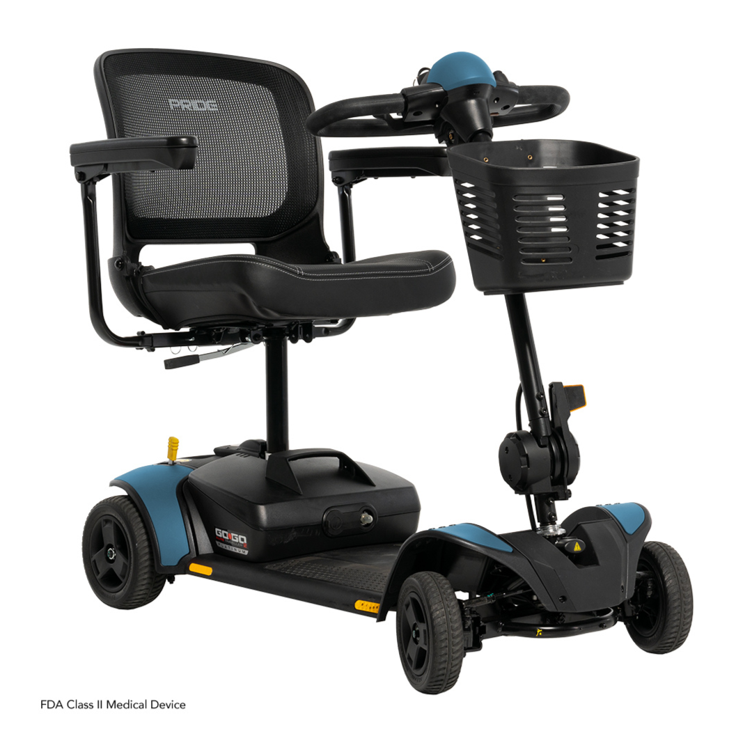 The Pride Mobility Go Go Elite Traveller® 2 Platinum Scooter is a compact three-wheeler with a mesh backrest, padded seat, front basket, and stylish blue accents on the wheel covers and handlebars.