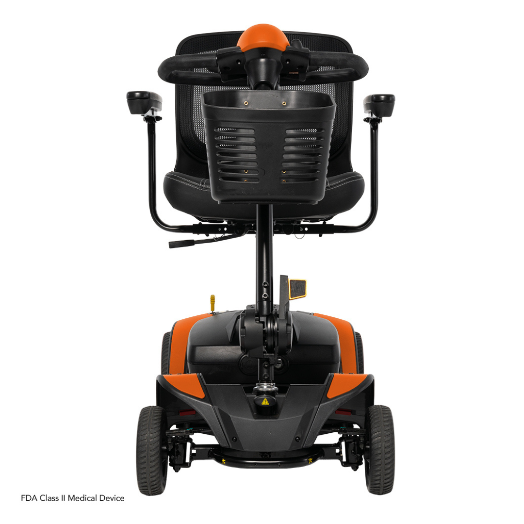 A compact, orange and black Pride Mobility Go Go Elite Traveller® 2 Platinum Scooter viewed from the rear, featuring two large rear wheels, a padded seat with armrests, and a curved backrest.
