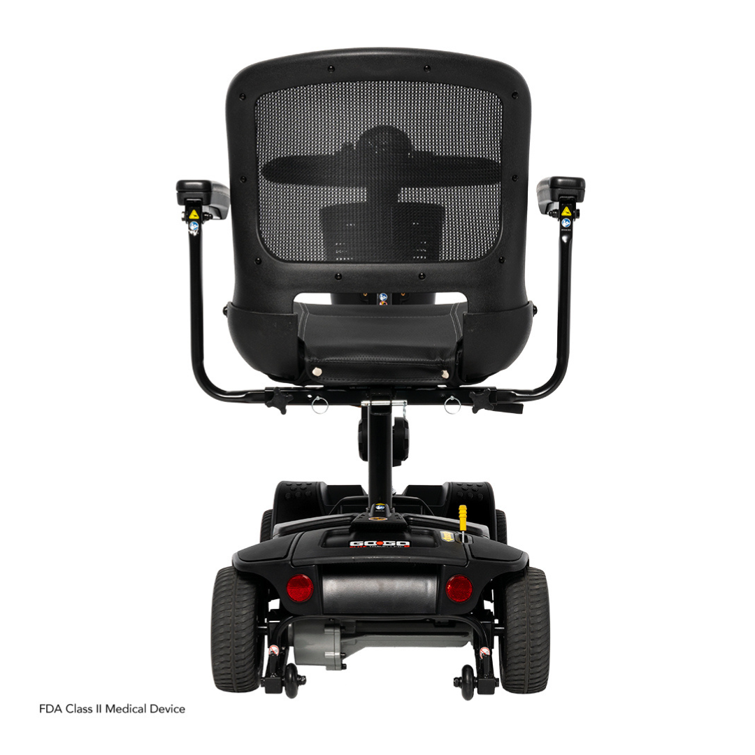 Rear view of a black Pride Mobility Go Go Elite Traveller® 2 Platinum Scooter with mesh backrest, armrests, and four wheels on a white background. Features EZ Turn technology, rear lights, and an FDA Class II Medical Device label.