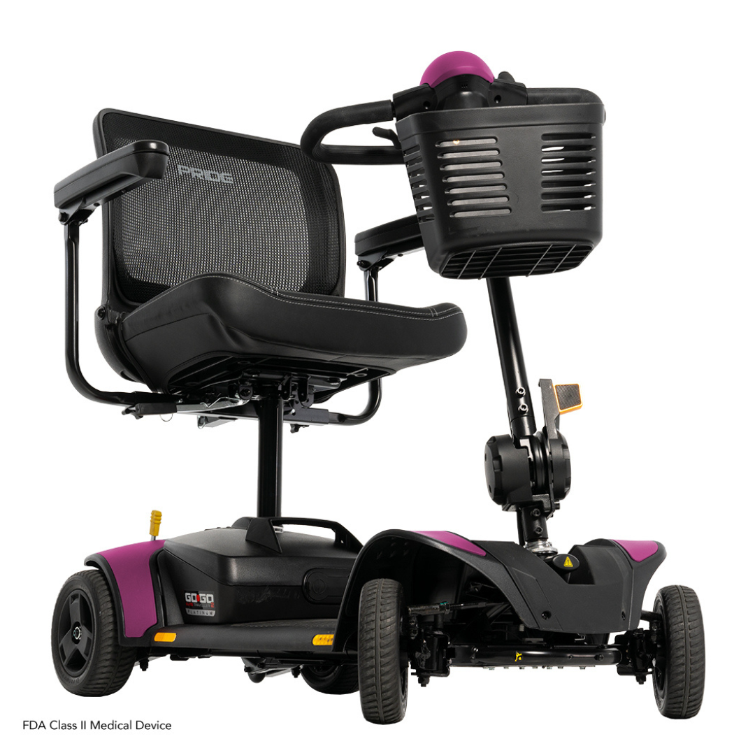 The Pride Mobility Go Go Elite Traveller® 2 Platinum Scooter is a black and purple three-wheel travel scooter with mesh backrest, padded seat, front basket, and is FDA Class II approved for safe personal transportation.