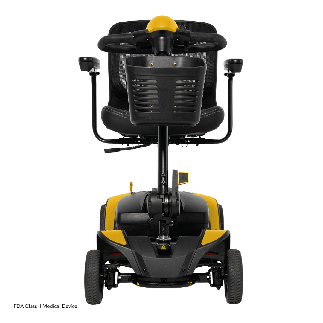 A yellow and black Pride Mobility Go Go Elite Traveller® 2 Platinum Scooter is shown from the back, highlighting its seat, armrests, and four wheels on a white background. Text at the bottom states: FDA Class II Medical Device.