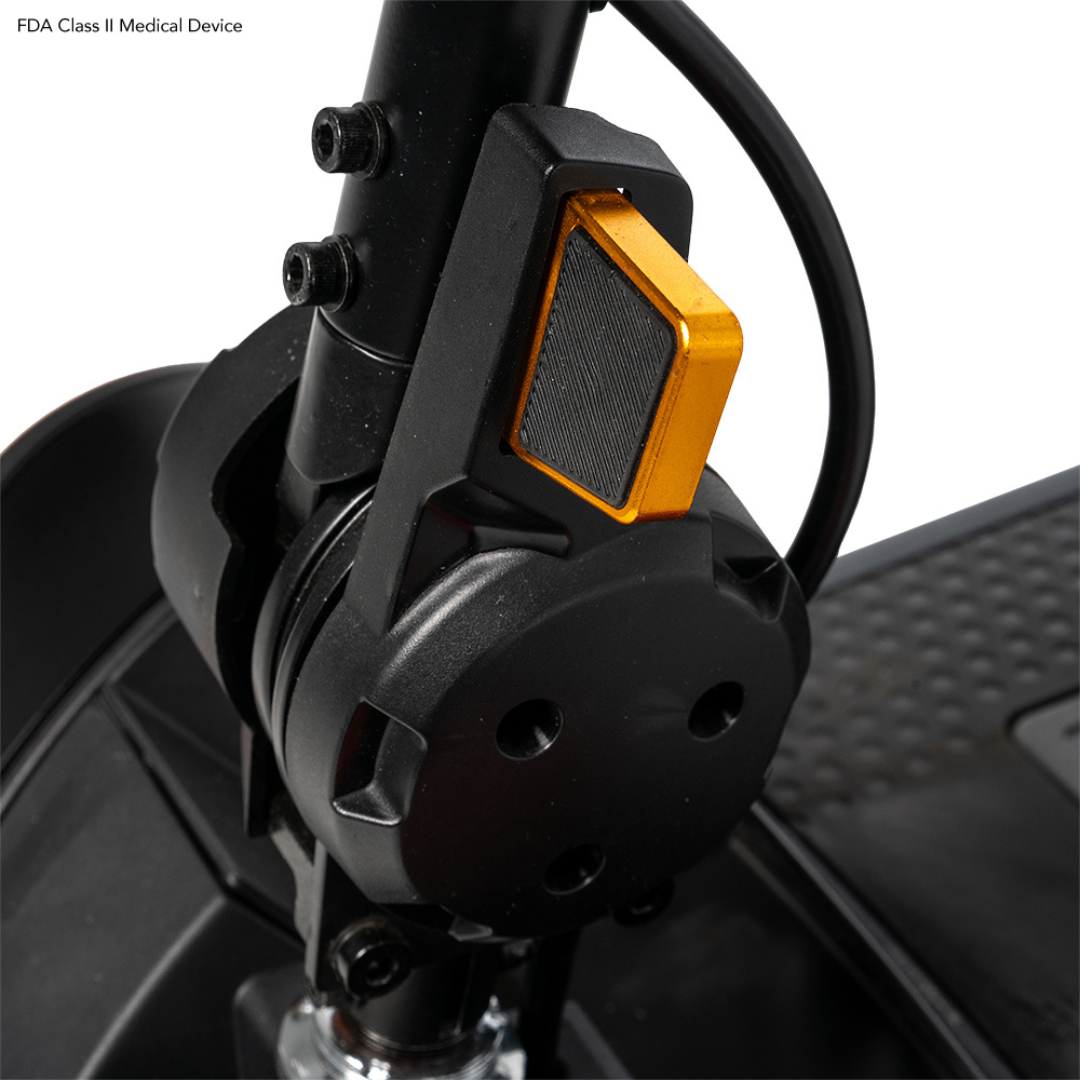 Close-up of the Pride Mobility Go Go Elite Traveller® 2 Platinum Scooter's black folding mechanism with a yellow locking lever and attached cables. The textured footrest is partially visible, showcasing its portability-focused design.