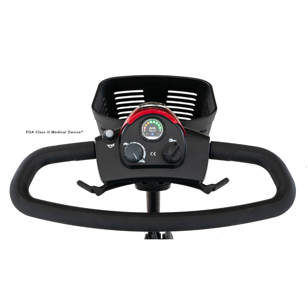 Close-up of a Pride Mobility Go Go® Elite Traveller 3-Wheel Scooters control panel with speed dial, light switch, and battery indicator. Above it is a wire basket. As an FDA Class II Medical Device, its lightweight design offers travel-friendly easy maneuverability for all users.