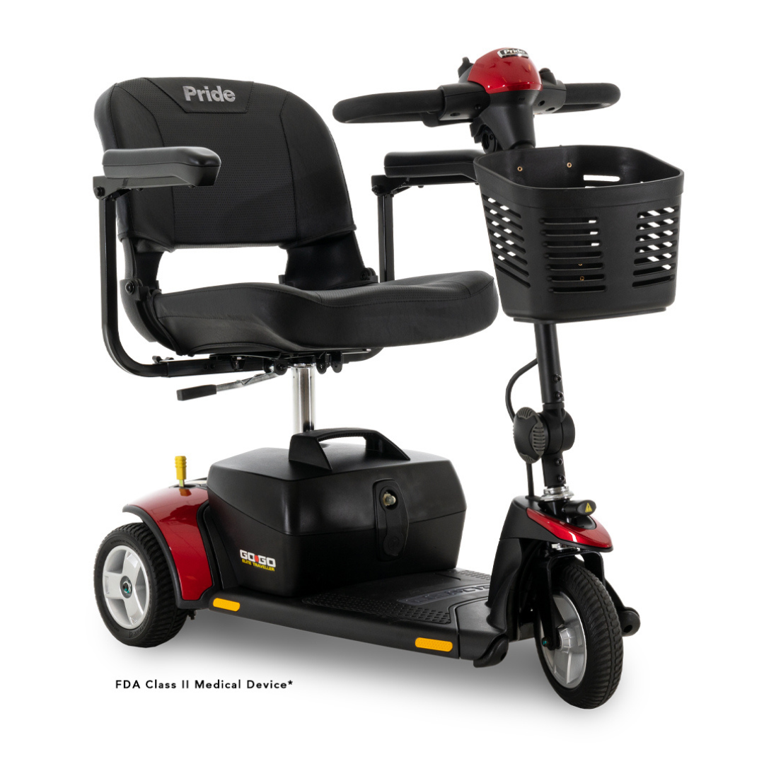The Pride Mobility Go Go® Elite Traveller 3-Wheel Scooter, in black and red, includes a seat with armrests, a front basket, and handlebar controls. Its lightweight, travel-friendly design ensures easy portability. This scooter is classified as an FDA Class II Medical Device.
