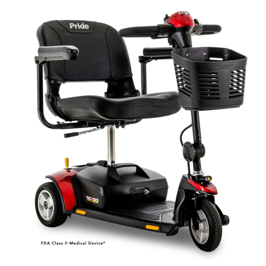 The Pride Mobility Go Go® Elite Traveller 3-Wheel Scooter in red and black has a lightweight, travel-friendly design with a seat, handlebars, and front basket. The Pride logo is on the backrest, and its sturdy modular frame allows one-handed disassembly.