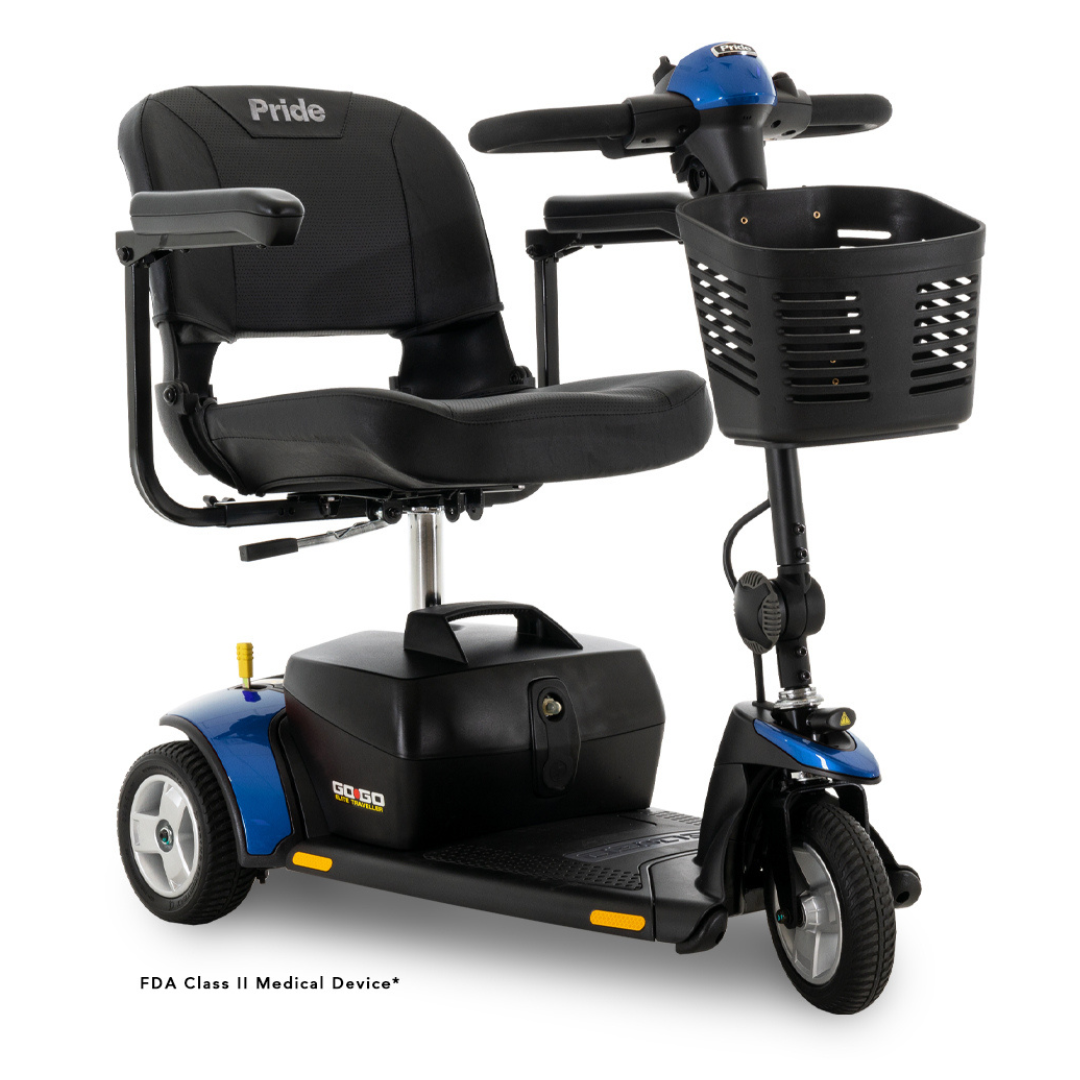 The Pride Mobility Go Go® Elite Traveller 3-Wheel Mobility Scooter is blue and black with a comfortable seat, handlebars, and a front basket. As an FDA Class II Medical Device, it features lightweight one-handed frame separation for easy transport. Shown on a plain white background.