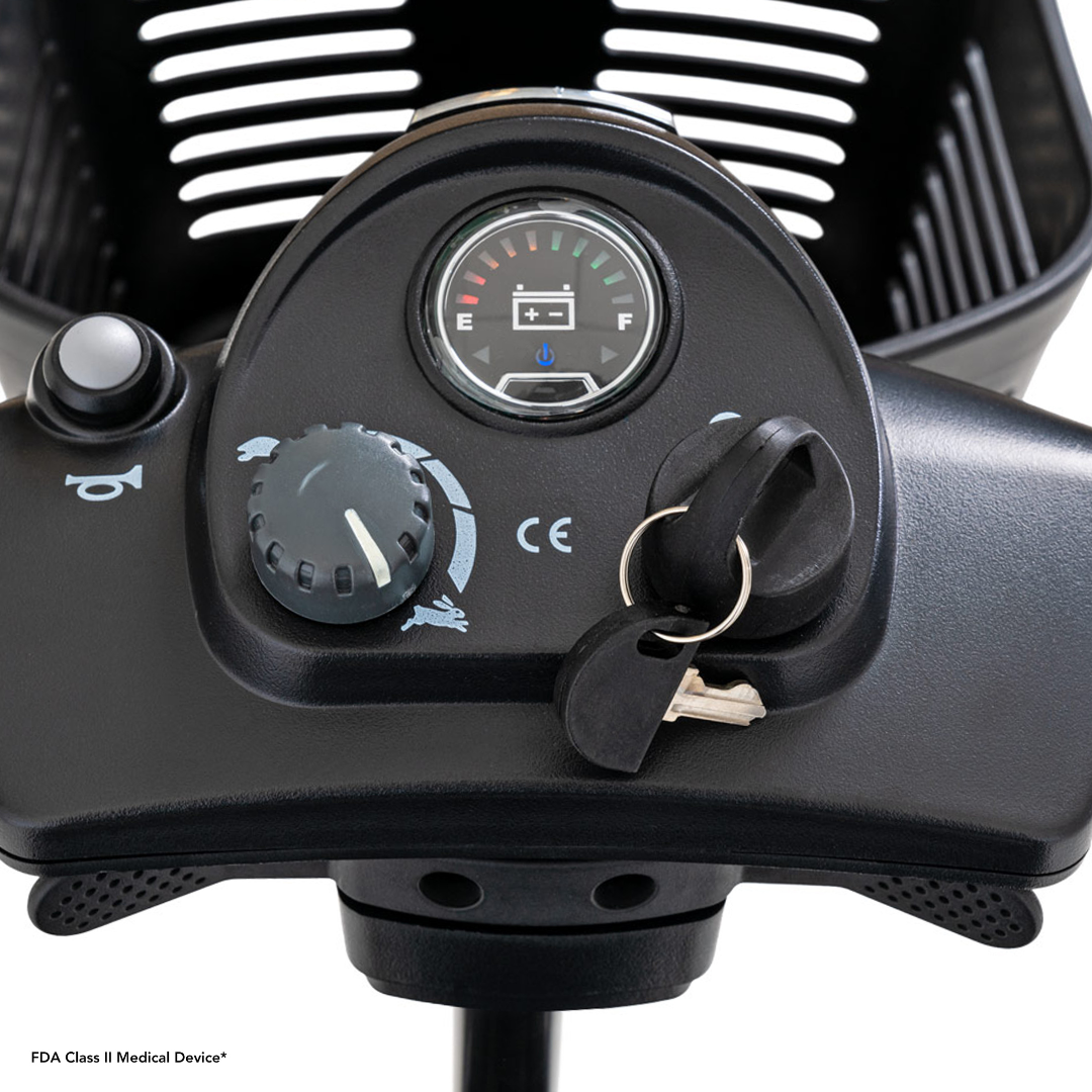 Close-up of the Pride Mobility Go Go® Ultra X 3-Wheel Scooters control panel, showcasing a sleek design with a speed dial, battery meter, and ignition key. This economy-class scooter features clear labeling for easy navigation and functionality.