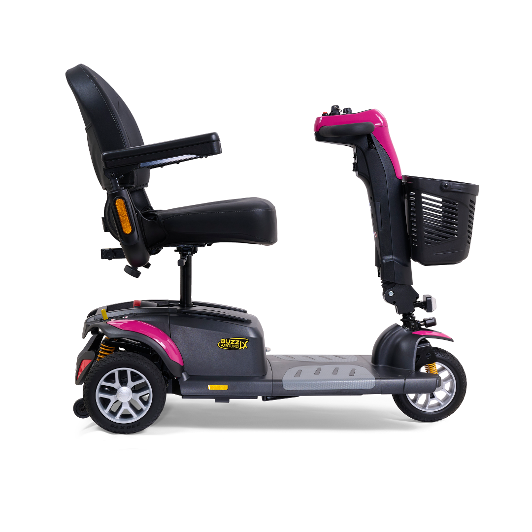 Here's a side view of the Golden Buzzaround LX GB119, a heavy-duty three-wheel portable mobility scooter in pink and gray. It boasts a black cushioned seat with armrests and features a convenient front basket. Its compact and modern design offers easy transportation and maneuverability, perfectly capturing the essence of luxury mobility from Golden Technologies.