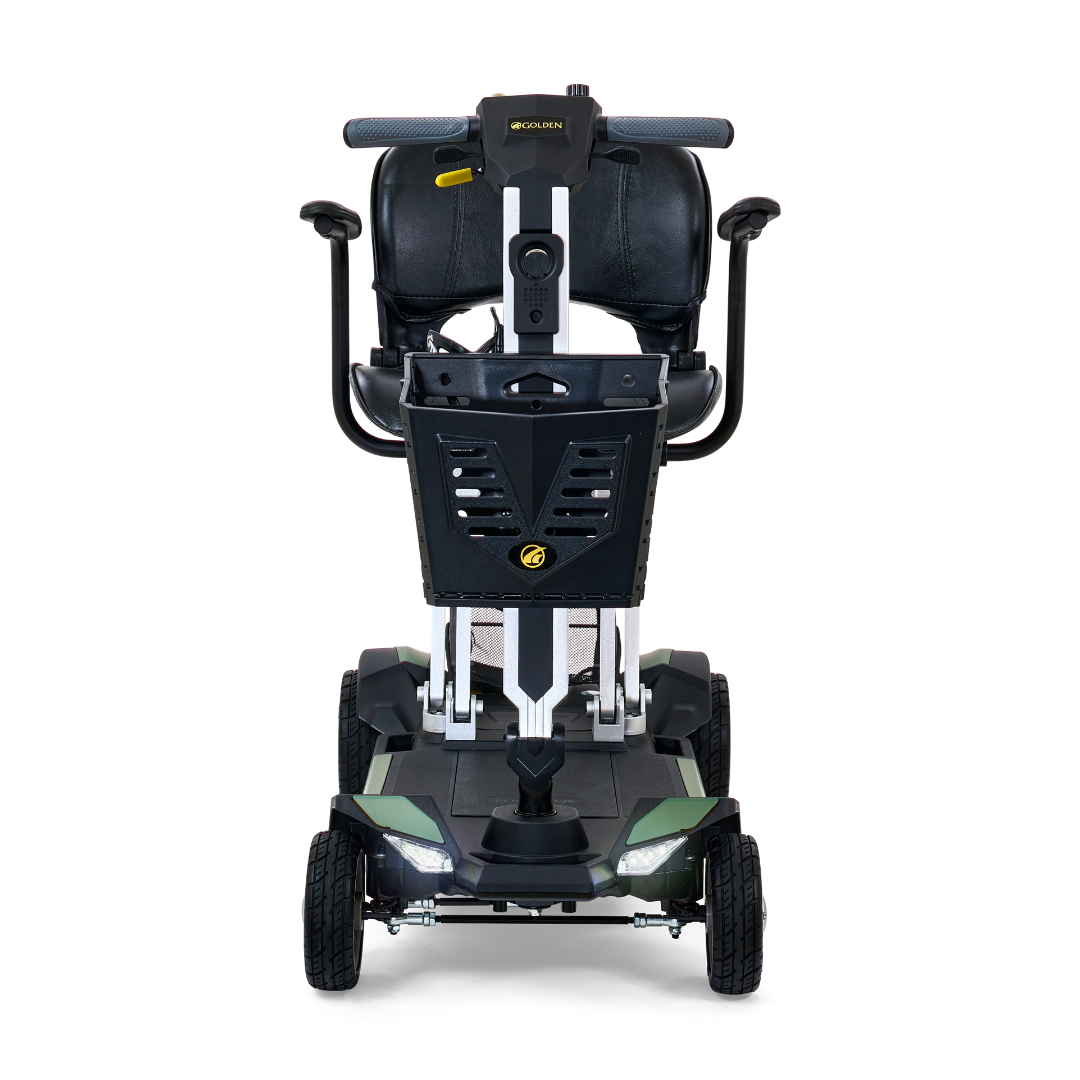 A front view of the Golden Technologies Portable Buzzaround GB120 Carry-On Travel Scooter showcases its ultra-portable design with a black seat equipped with armrests, a handlebar, and a storage compartment at the back. This modern scooter features four wheels and is predominantly styled in black and gray colors, powered by a lithium-ion battery.
