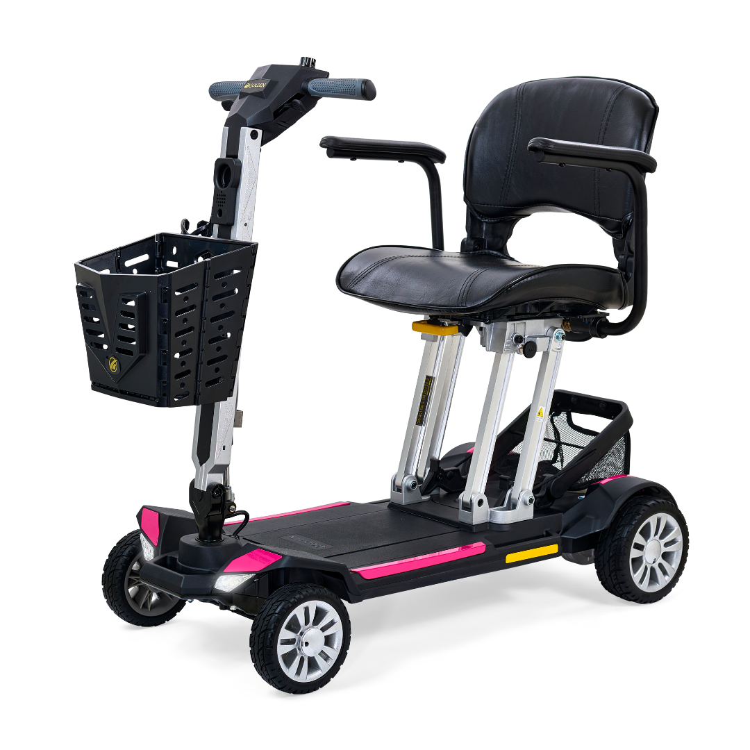 The Golden Technologies Portable Buzzaround GB120 Carry-On Travel Scooter is an ultra-portable, compact mobility scooter in black, featuring a spacious seat, a small basket on the handlebars, and four sturdy wheels. With stylish pink accents and a sleek modern design, it offers a convenient fold-flat feature and an efficient lithium-ion battery for easy storage and impressive performance.