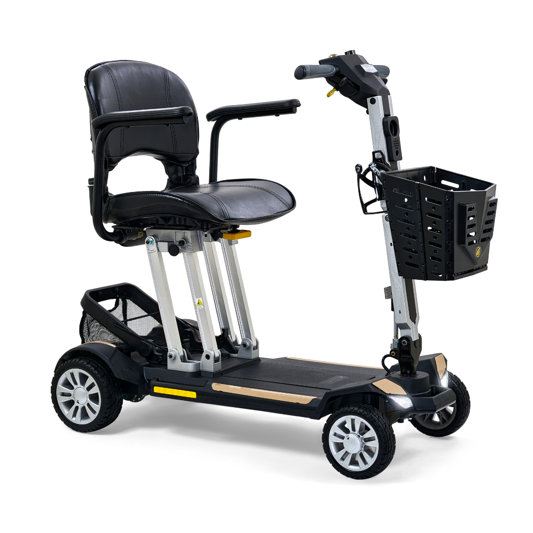 The Golden Technologies Portable Buzzaround GB120 Carry-On Travel Scooter offers a fold-flat design with four wheels and a cushioned black seat complete with armrests. This ultra-portable scooter includes a small black front basket, sturdy metal frame, and features a wooden footrest for added stability.